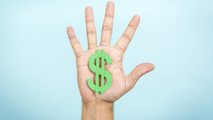 Hand up showing/catching a green dollar symbol with blue backgro